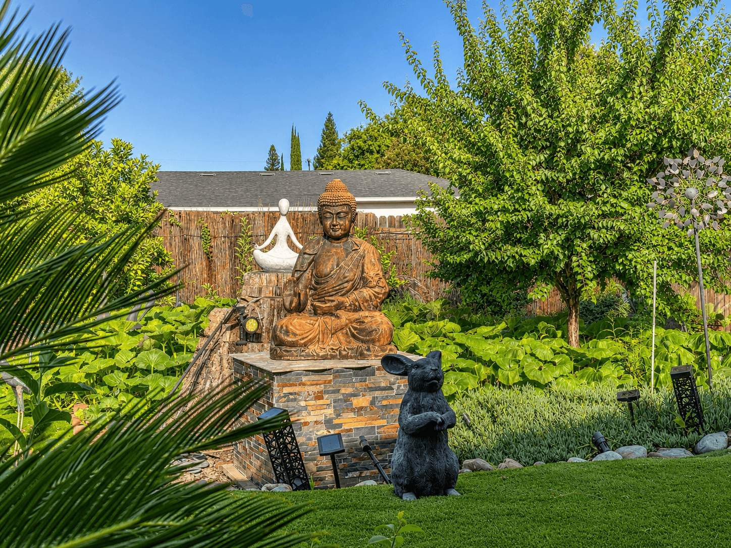 Buddha and meditation statue in lush zen garden at The Oaks at Garfield